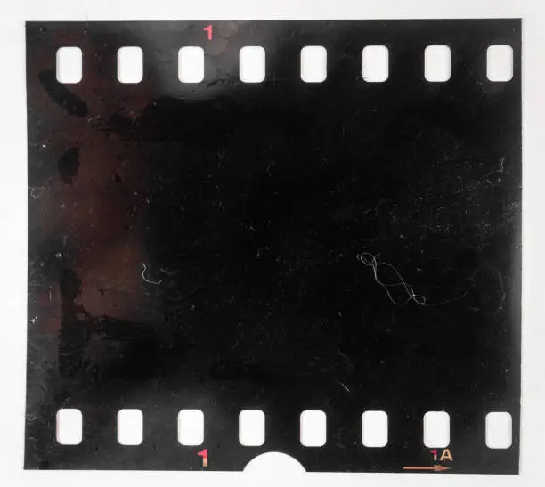 Photo of Real and original 35mm or 135 film material on white background, 35mm filmstrip
