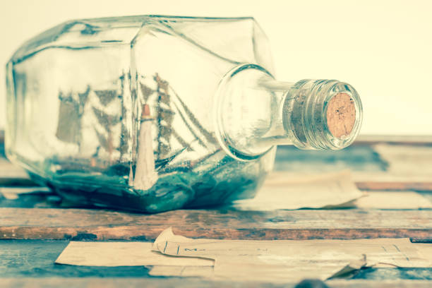 istock A vintage whiskey bottle containing a ship and light house, resting on a trunk 1093684186