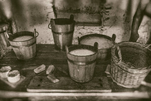 Old way of making cheese and diary products, buckets of milk, cream and soured milk on wooden table stock photo