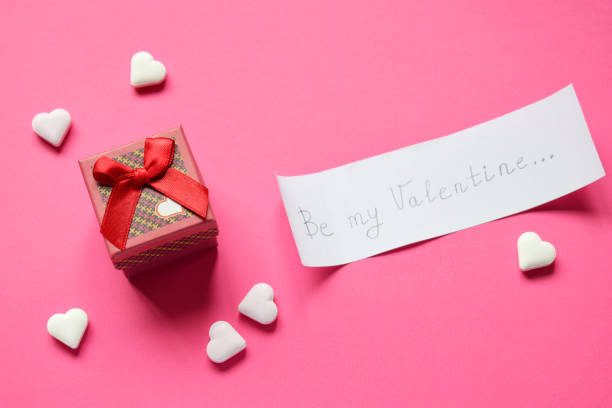 istock Small present box and paper with text be my Valentine on pink background. Valentine's Day Gift or greeting card concept. 1093686070