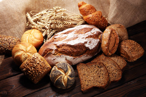 istock Different kinds of bread and bread rolls on board from above. 1093688584