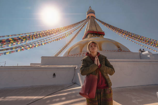 femme blonde dans le temple de bodnath stupa - bodnath stupa kathmandu stupa flag photos et images de collection