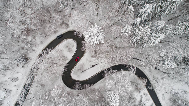 vista aerea di una strada sinuosa in inverno - winterroad foto e immagini stock