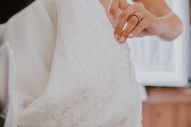 istock Bride's hands unbuttoning wedding dress 1093698316