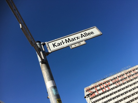 Karl-Marx-Allee street sign under a blue sky, Berlin, Germany.