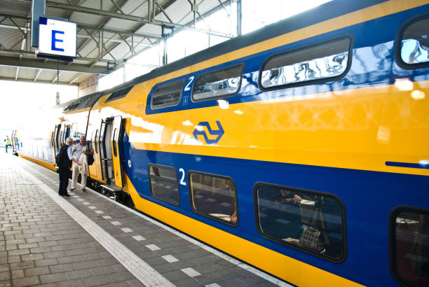 wachten pendelaars/toeristen op staande in de buurt van een trein van de ns (nederlandse spoorwegen) op platform e bij station eindhoven, nederland - trein nederland stockfoto's en -beelden