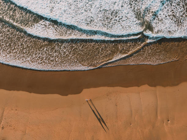 istock Couple holding hands at beach from above 1093702088
