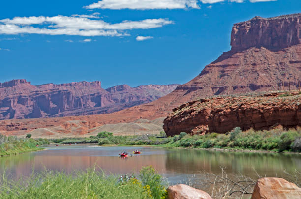 istock Paddlers play on the river beneath red sandstone cliffs. 1093702248