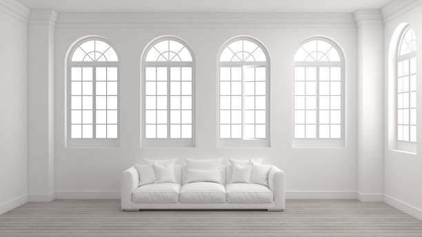 stanza degli interni con parete bianca, pavimento in legno, finestre ad arco e un divano. - window arch white indoors foto e immagini stock