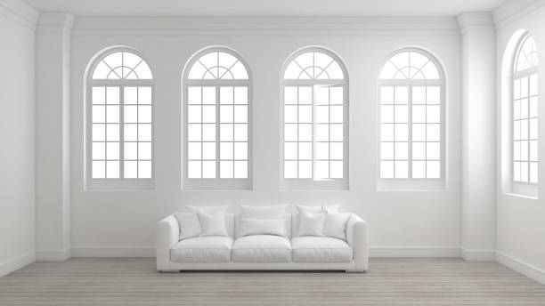 Room of interior with white wall, wooden floor, arched windows and a sofa.