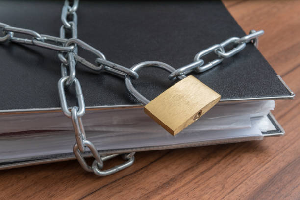 istock Confidential files and documents in binder locked with padlock and chain. Privacy and security concept. 1093711134