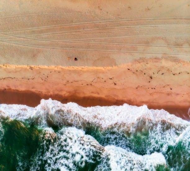 istock Abstract Aerial View of Sandy Beach and Small Waves from Above 1093718424