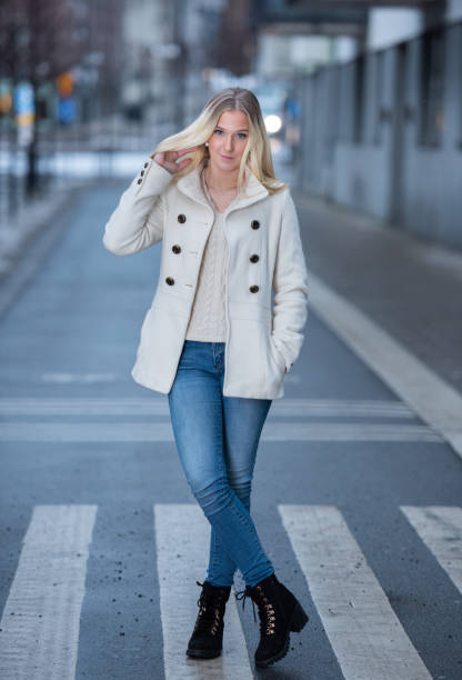 istock Blonde woman, white winter coat, posing, looking at camera 1093719366