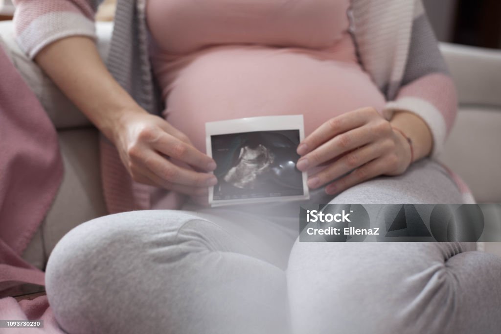 Mother expecting a baby. Close up photo of pregnant woman belly. Holding Stock Photo
