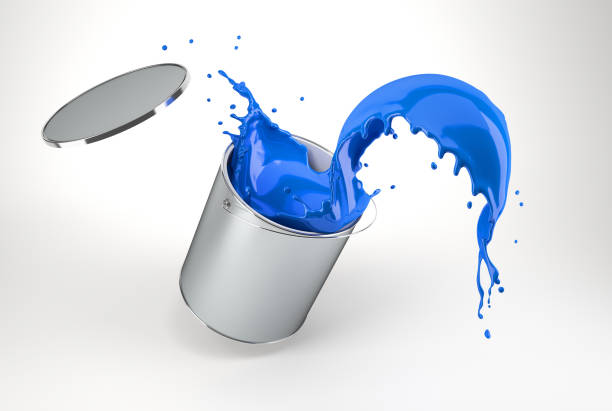 silver bucket full of vibrant blue paint, jumping with paint splashing. stock photo