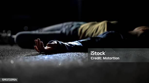 Bloody Female Victim Of Deadly Car Accident Lying On Road Closeup View At Body Stock Photo - Download Image Now