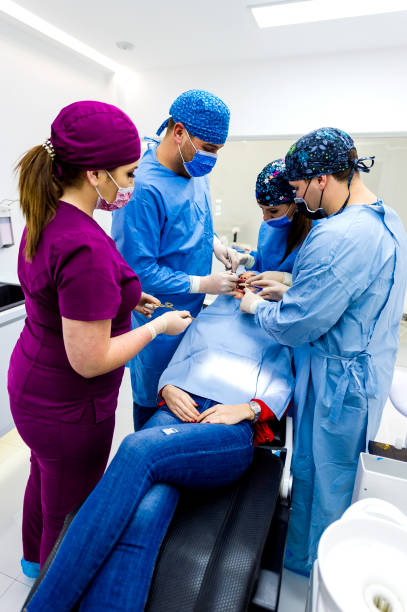 istock Group of Young Dentists Working on Patient in Dentist Office 1093734326