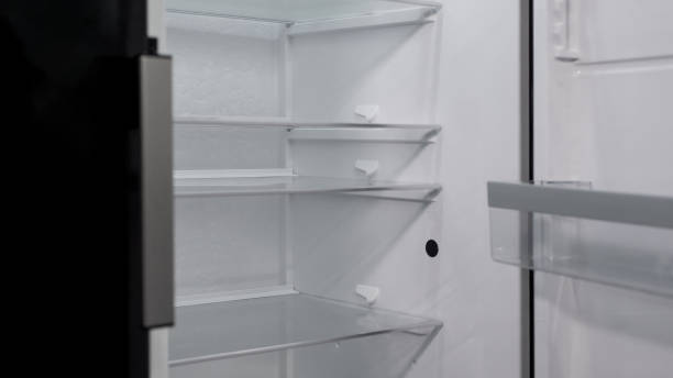 istock Opened empty refrigerator on exposition of kitchen appliances, fridge purchase 1093734370