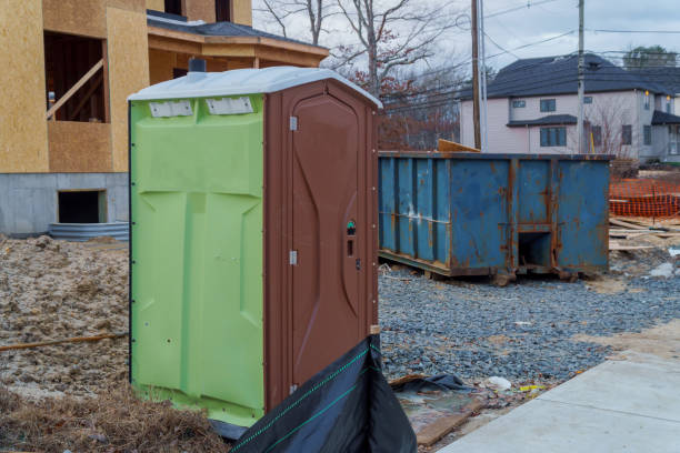 istock Portable restroom on a dumpsters being full with garbage new house under construction. 1093736240