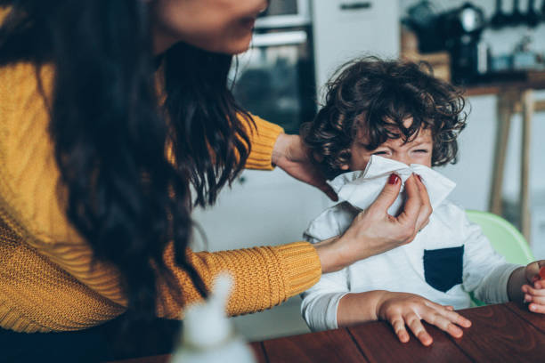 istock Mother helping son to blow his nose 1093740658