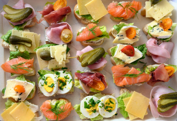 various canapes with egg, cheese, ham and salmon on a tray at the cold buffet, high angle view from above