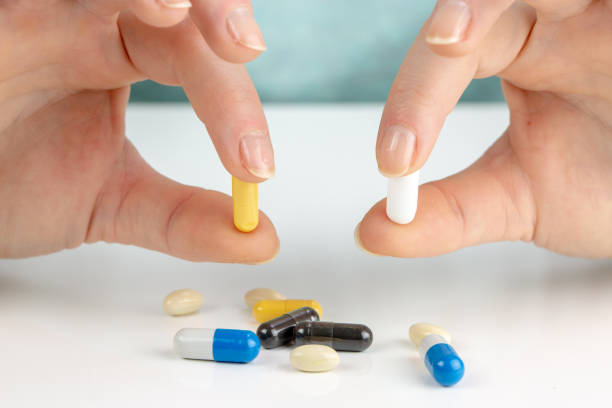 istock Closeup on young woman choosing pills 1093749010