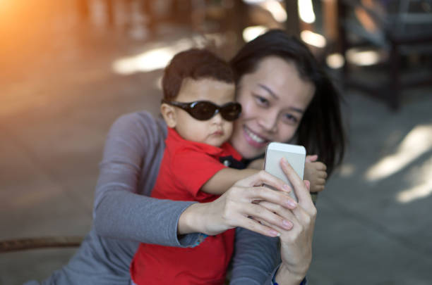 istock Smiling Woman With Son Taking Selfie Through Mobile Phone 1093751740