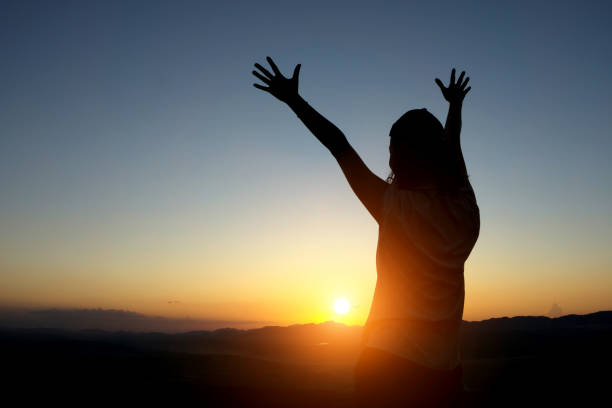 istock Silhouette Woman With Arms Raised Standing Against Sky During Sunset 1093752132