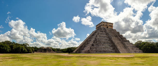 Chichen itza archaeological site, Yucatan - Mexico Chichén Itzá is the largest of the archaeological cities of the pre-Columbian Maya civilization in the Yucatan Peninsula of Mexico. It was granted World Heritage Site status in 1988 by UNESCO World Heritage Site and was recently selected as one of the New Seven Wonders of the World. The Pyramid of Kukulcan is the most famous landmark of Chichen Itza. This was a temple-pyramid dedicated to the Feathered Serpent God, Kukulcan. Sculptures of the Feathered Serpents run down the sides of the northern staircase, and are set off by shadows from the corner tiers on the Spring and Fall equinox maya temple stock pictures, royalty-free photos & images