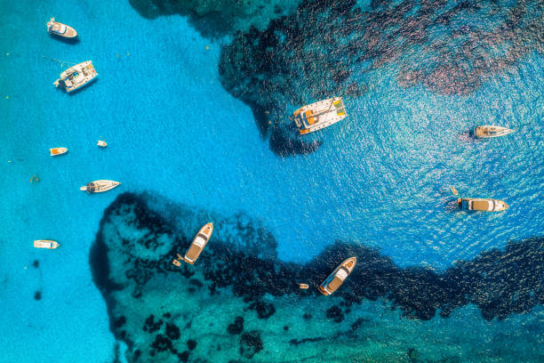 Aerial view of boats and luxury yachts in transparent blue sea at sunny day in Spain. Colorful landscape with marina bay, azure water. Balearic islands. Top view. Travel in Europe. Summer vacation stock photo