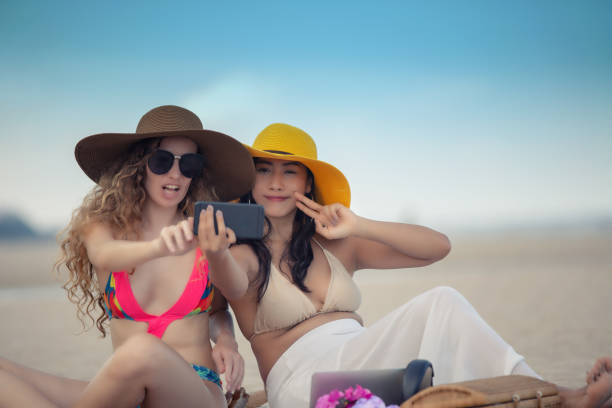 istock Female Friends Taking Selfie At Beach 1093755720