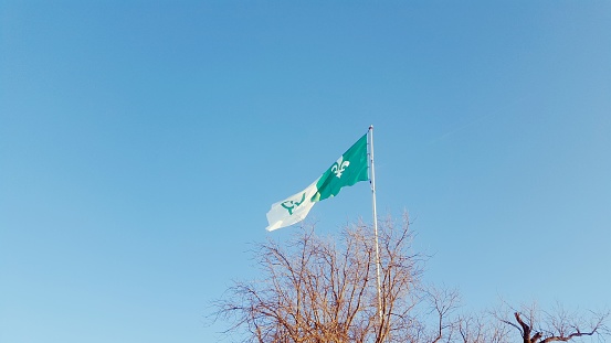 Low-dive view of the Franco-Ontarian flag flying in the wind