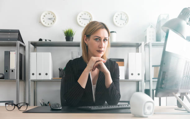 istock A young girl sitting at a table in the office. 1093761790