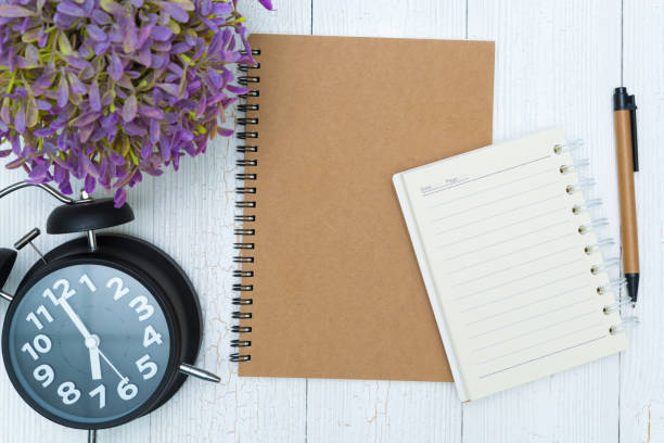 istock Blank notebook paper and pen on the wood, top view. 1093763510