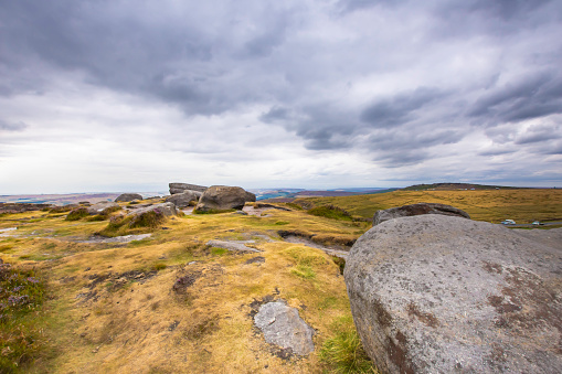 Landscape uk.Stunning view from top of the hill with boulders on beautiful mountain valley.Panorama of moorland.Scenics-Nature.Dramatic sky over hills of central England.