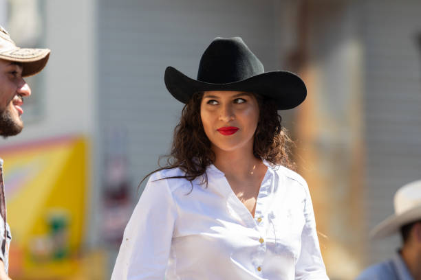 Chicago, Illinois, USA - September 15, 2018: Pilsen Mexican Independence Day Parade, Young mexican woman, riding a horse, wearing a black cobow hat