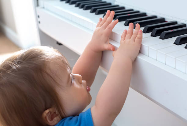 bambino che suona il pianoforte - toddler music asian ethnicity child foto e immagini stock