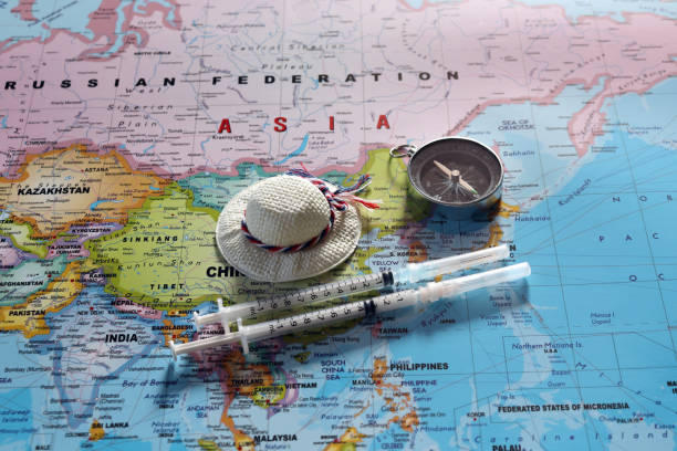 istock A compass with disposable syringes and travel cap on world map. 1093808766