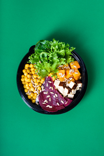 Hawaiian vegetarian poke bowl with tofu, chickpea, beetroot and pumpkin. Ready-to-eat, to go fast food. Healthy ingredients. Top view, flat lay.