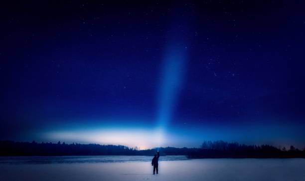 istock Surreal night landscape with alone strange man with flashlight. 1093828406