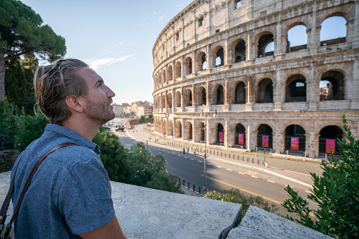 One man contemplating the Colosseum in Rome, Italy\nPeople travel enjoying capital cities of Europe concept