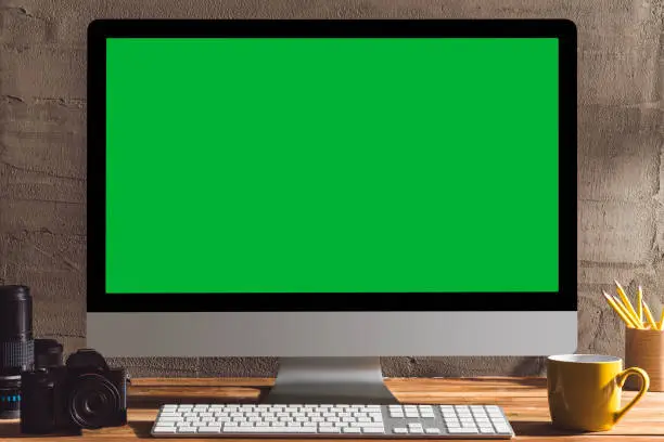 Photo of Chroma key green screen computer on table.
