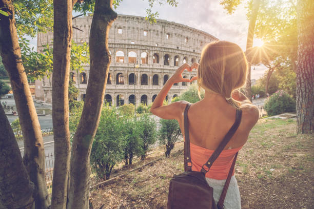 giovane donna al colosseo di roma che fa una cornice a forma di cuore con le mani che amano viaggiare in italia - italy coliseum rome italian culture foto e immagini stock