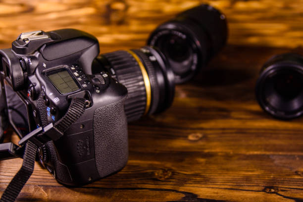 istock Modern dslr camera and lenses on wooden table 1093841850