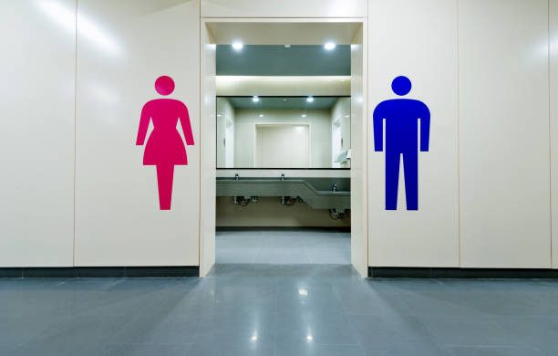 baños públicos con las muestras de hombres y mujeres - bathroom contemporary office sparse fotografías e imágenes de stock