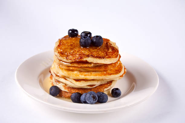 istock Pancakes with berries and honey on the white background 1093850470
