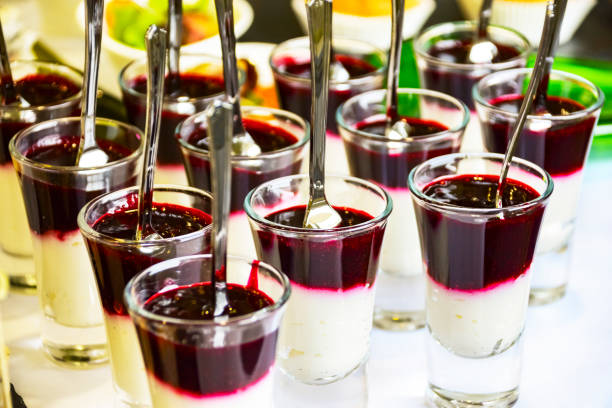 concetto di servizio di catering: parfait di budino di mousse di bacche negli scatti di vetro con cucchiai serviti a un evento aziendale, hotel, compleanno o celebrazione di matrimonio - luxury milk dinner glass foto e immagini stock