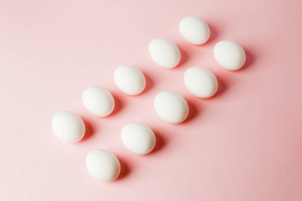 istock White eggs on a light pink background with reflection of the shadows and copy space. layout to easter. Flat lay, pattern 1093860402