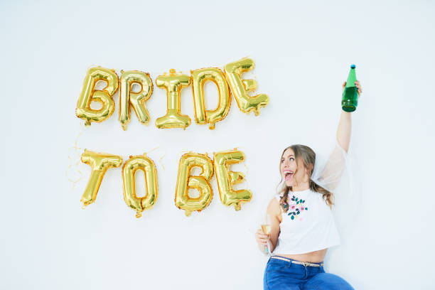 Marriage, bring it on! Studio shot of a happy young woman celebrating her engagement with “bride to be” in balloons on the wall bachelorette party stock pictures, royalty-free photos & images