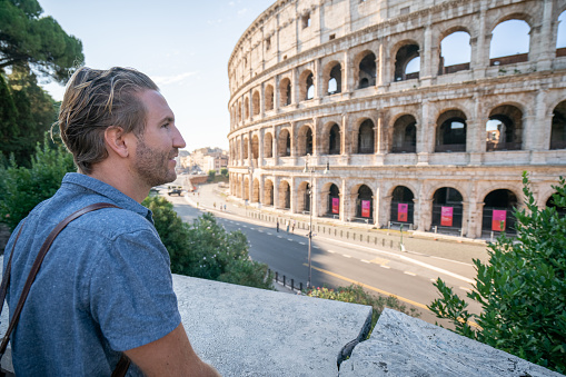 One man contemplating the Colosseum in Rome, Italy\nPeople travel enjoying capital cities of Europe concept